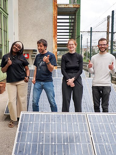 les 4 salariés du service support et accompagnement technique devant des panneaux photovoltaïques