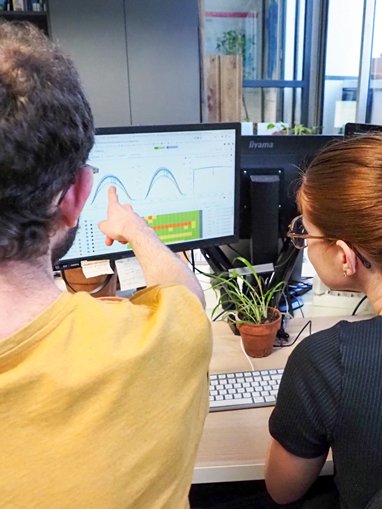 une personne accompagne et forme une autre personne sur le logiciel Épices dans un bureau